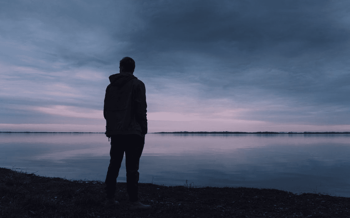 A man standing next to a lake