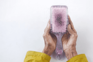 A hair brush with broken strands of hair