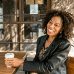 A woman smiling with a coffee cup