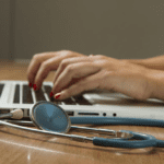 Close-up of a person typing on a laptop, depicting medical research on a cure for lupus.