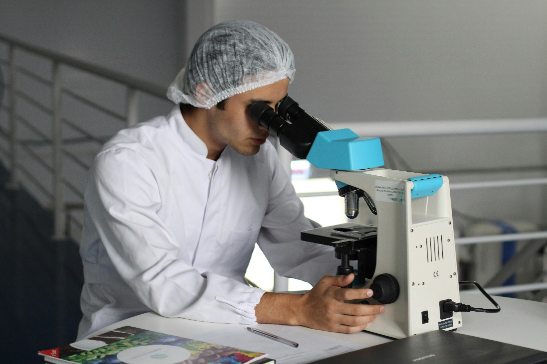 A medical professional looking in a microscope