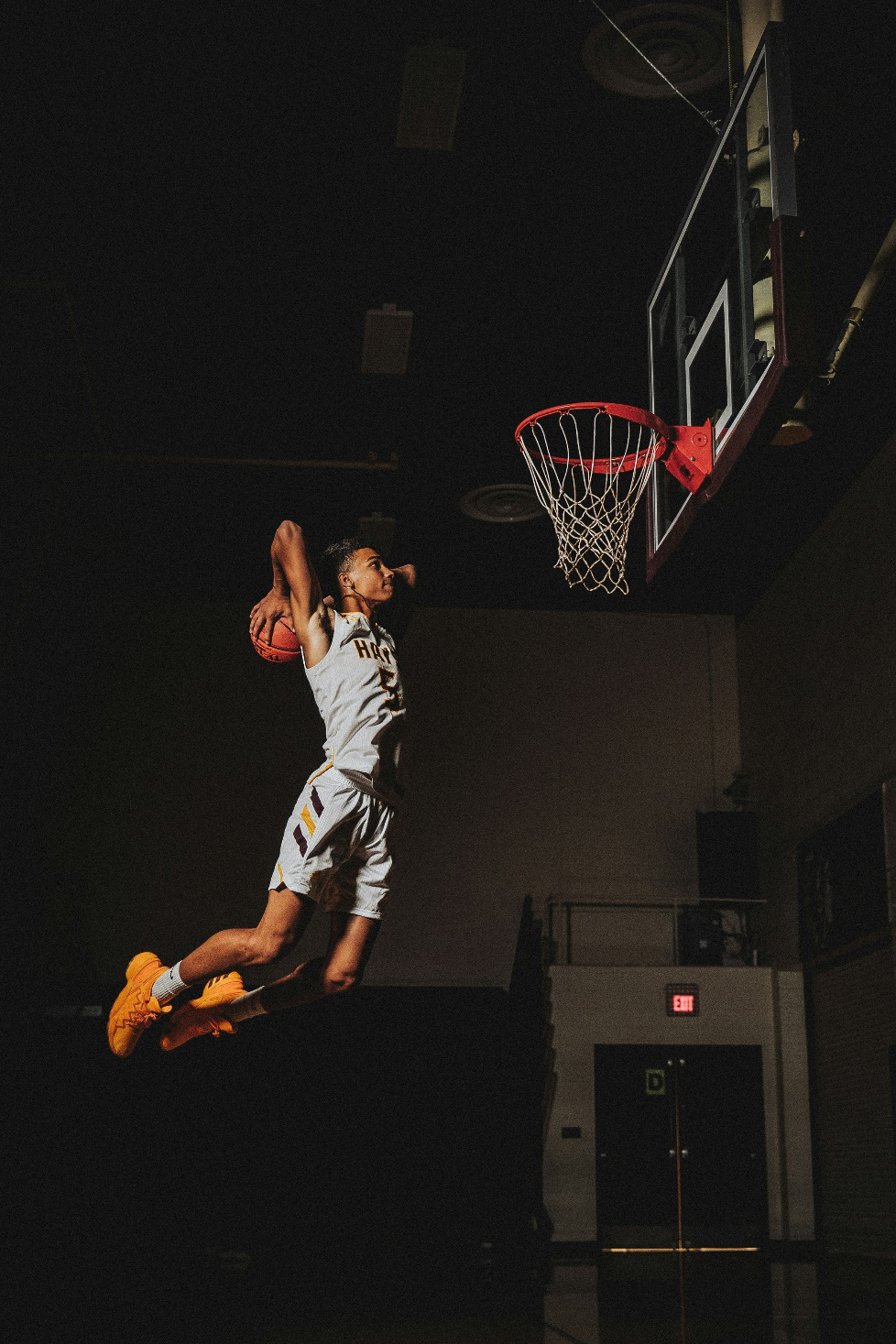 A person in mid-air for dunk.