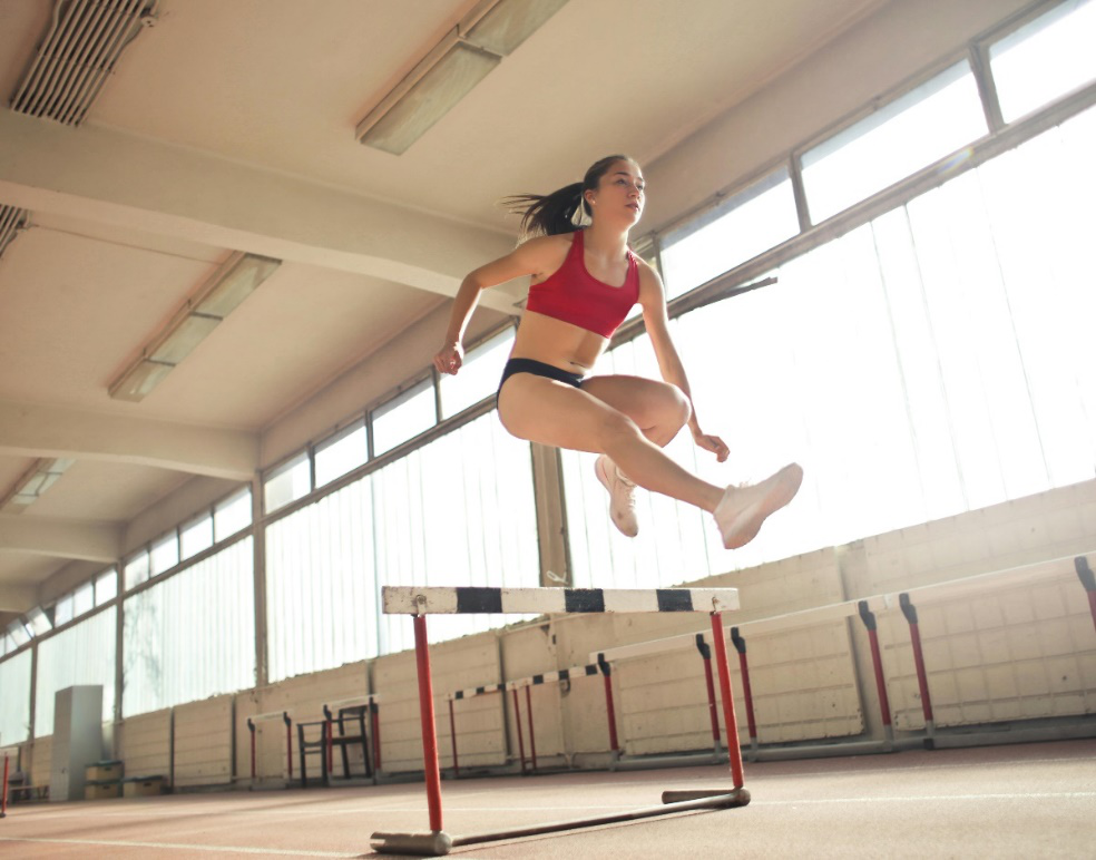 A woman jumping over an obstacle.