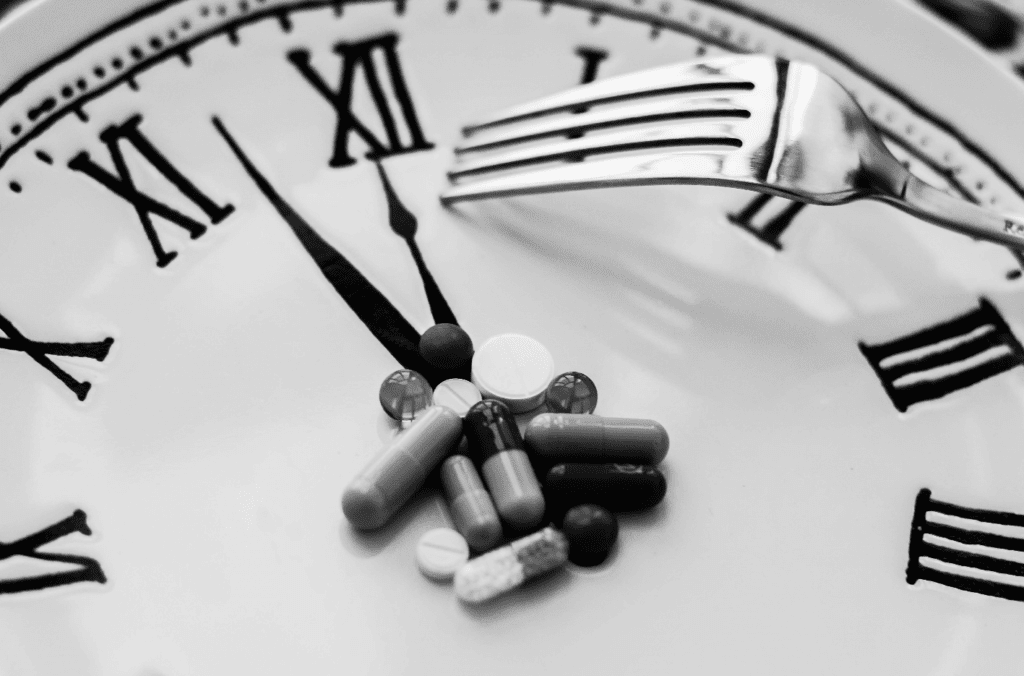 some pills and a for on a clock